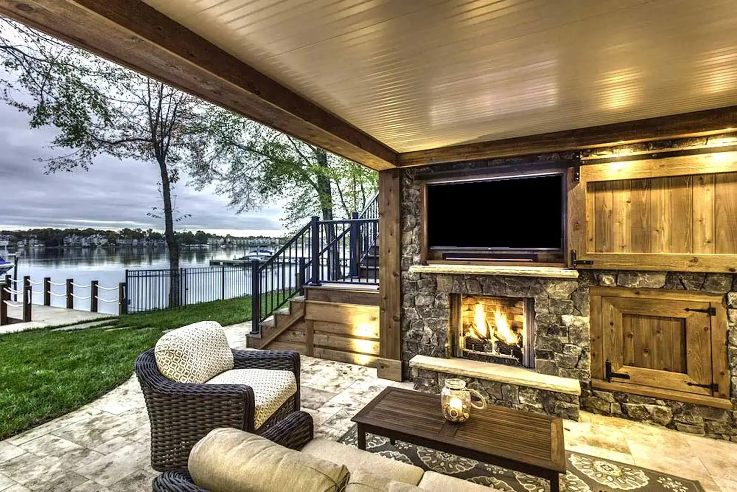 Covered patio with fireplace overlooking a lake.