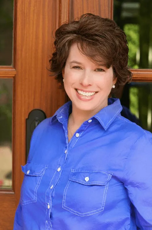 keystone-building-group-custom-homes-Angie-Smethers Smiling person in blue shirt outside door.