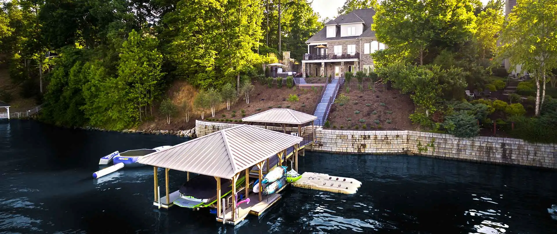 Lakeside house with dock and greenery.