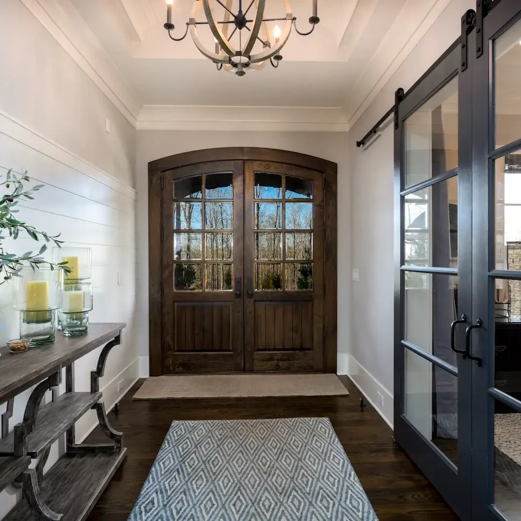20210224_7072-Ridgeway-Ln-0010 Elegant entryway with wooden doors and decor.