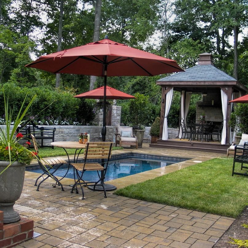 5 A patio with an umbrella and chairs by the pool