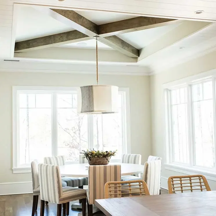 Custom-Home-Builder-Cozy-Lake-House-Breakfast-Nook-1-1 Bright dining room with modern ceiling design.