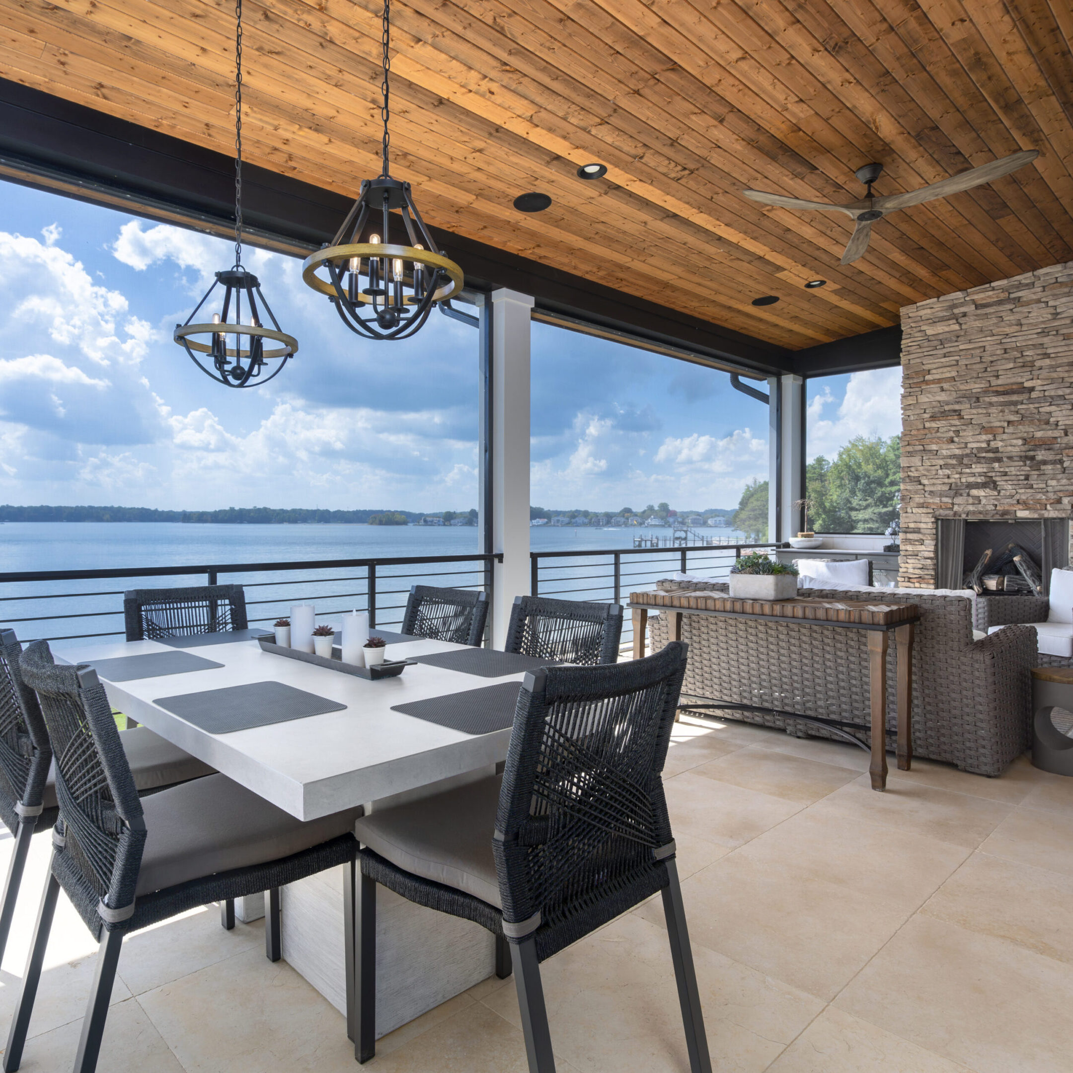 A dining room with an outdoor fireplace and a large balcony.